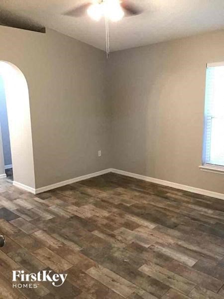 A room with a wooden floor and a window.