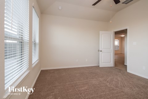 a living room with a carpeted floor and large windows