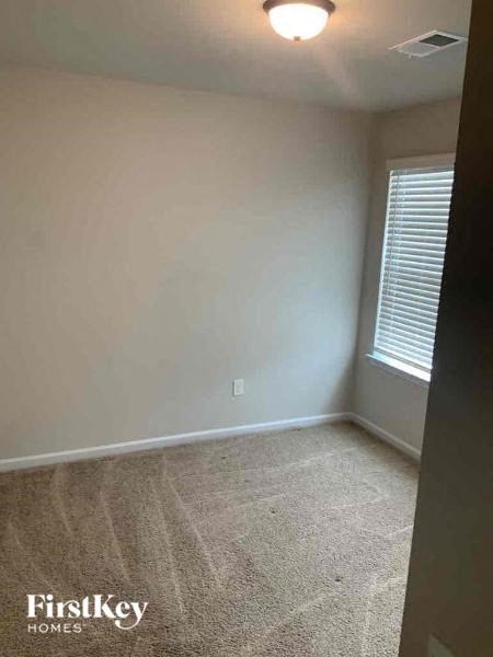 an empty room with a window and a carpet