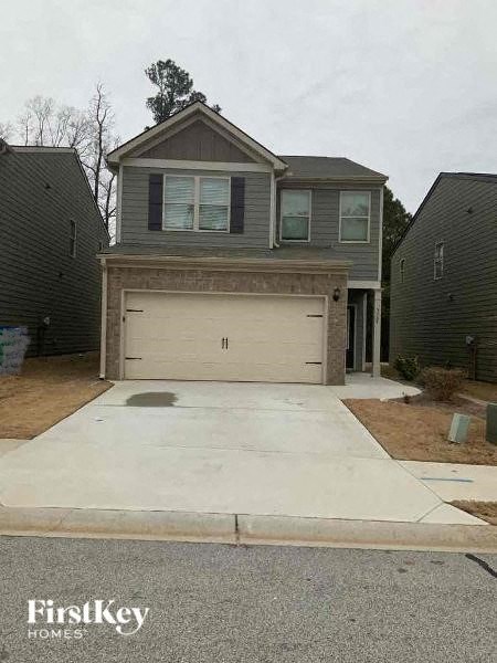 a white driveway in front of a house with a garage door