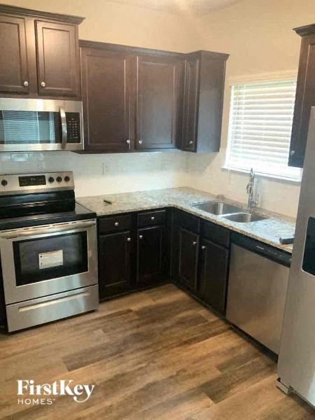 a kitchen with stainless steel appliances and wooden floors