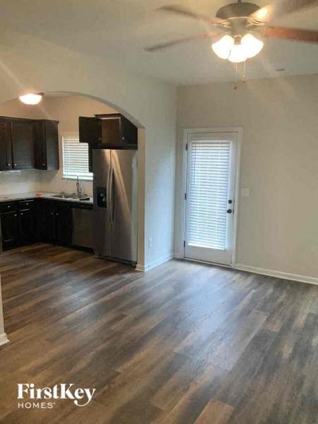 an empty kitchen with a refrigerator and a door