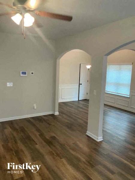 an empty living room with a ceiling fan