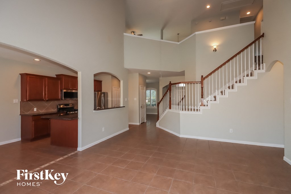 a staircase in the center of a large room with a kitchen and a stairwell