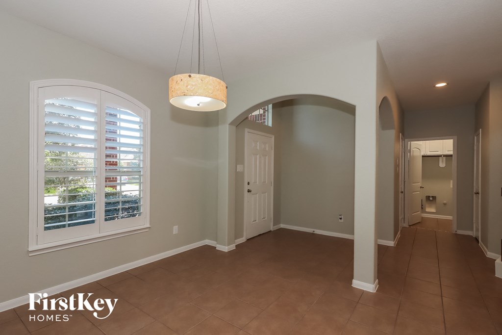 a dining room with a large window and a door to a hallway