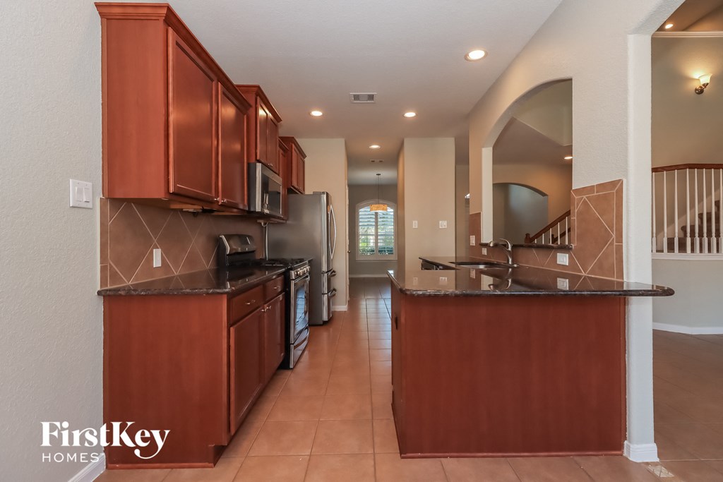 a kitchen with wood cabinets and black counter tops and a sink