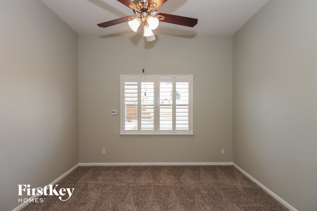 a bedroom with a ceiling fan and a window
