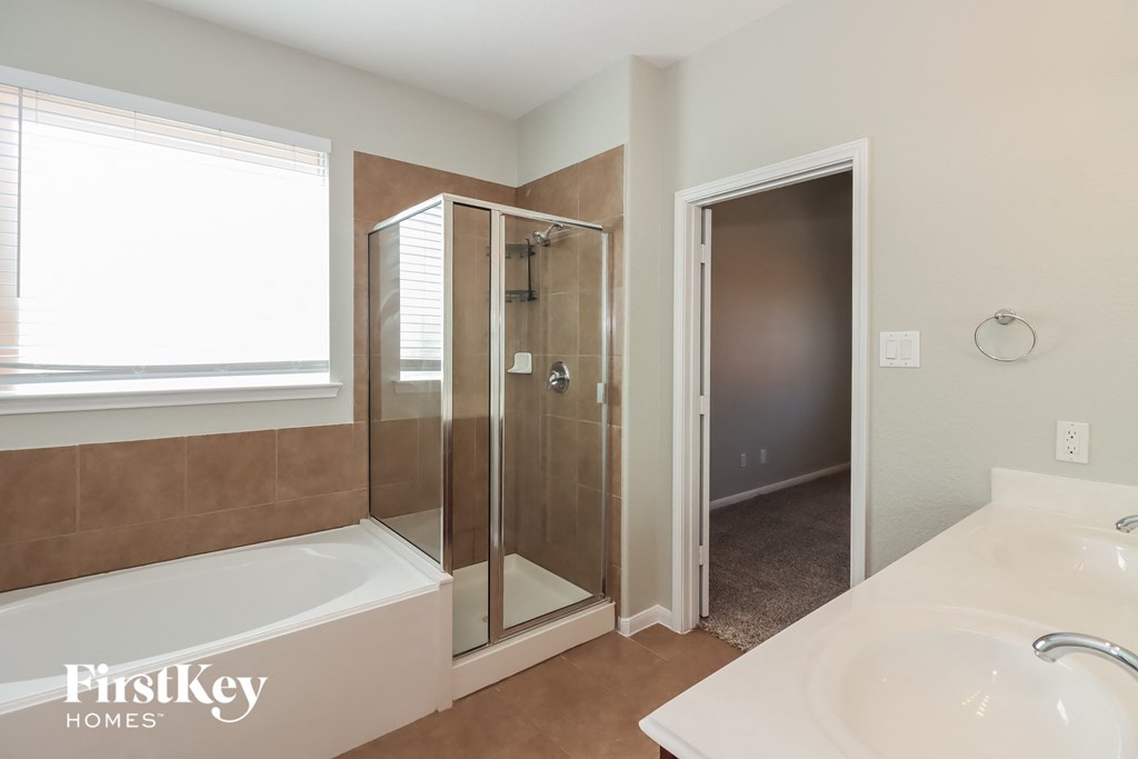 a bathroom with a tub and a shower and a sink