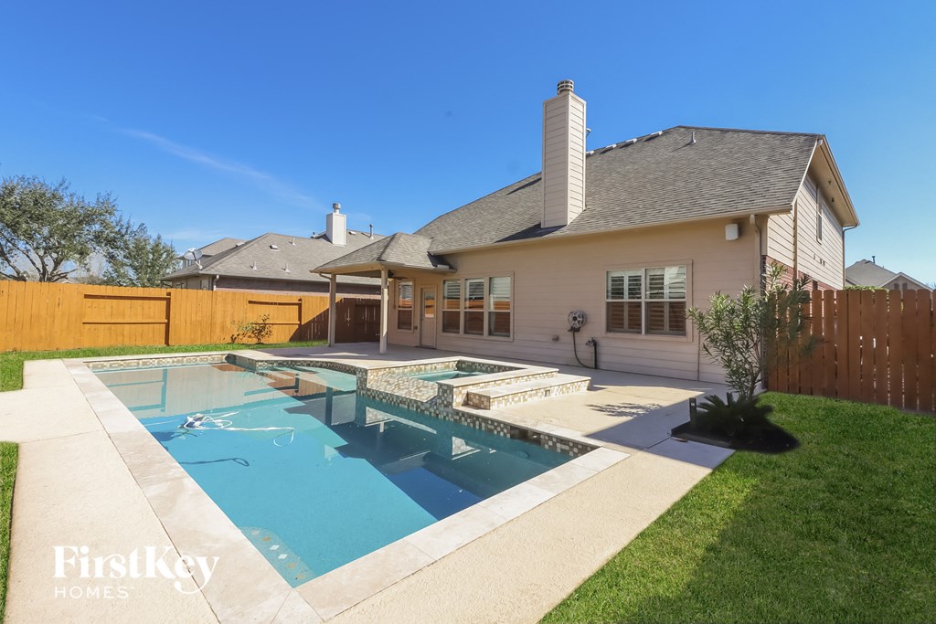 a backyard with a pool and a house