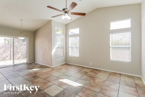 A spacious room with a ceiling fan and tiled flooring.