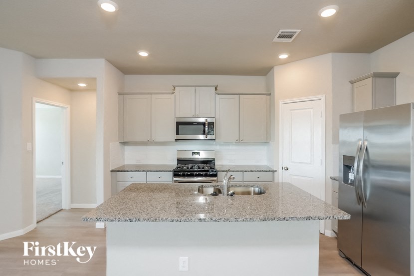 A kitchen with granite countertops and stainless steel appliances.