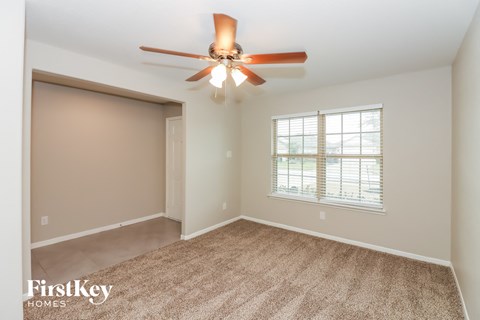 a bedroom with a ceiling fan and a window
