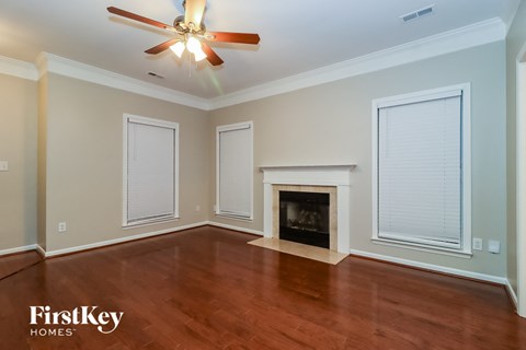 A room with a fireplace and a ceiling fan.