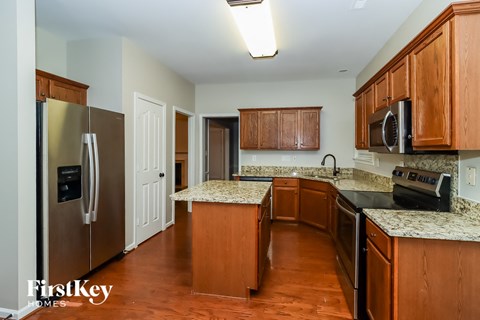 A kitchen with wooden cabinets and a granite countertop.