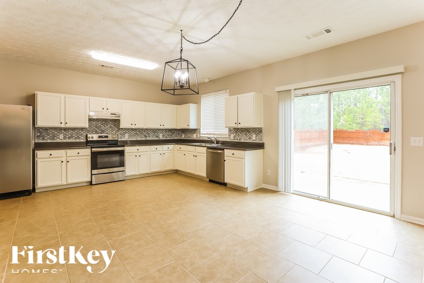 A kitchen with a tile floor and a hanging light fixture.