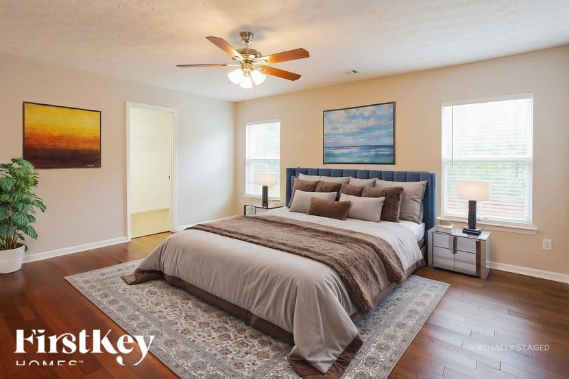 A bedroom with a large bed and a ceiling fan.