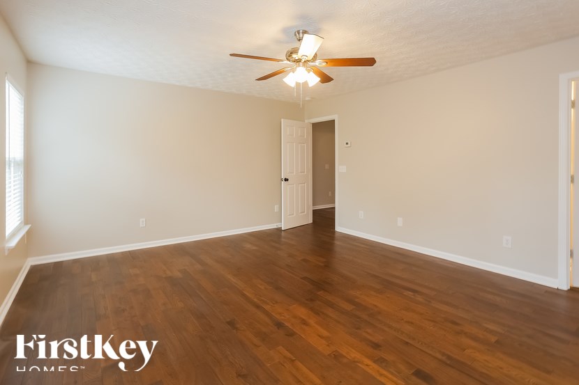 A room with wooden floors and a ceiling fan.