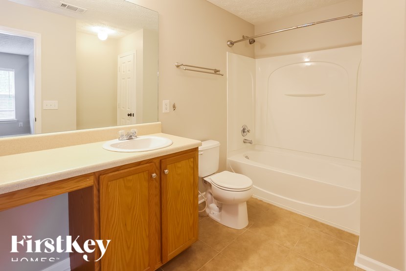 A bathroom with a toilet, sink, and tub.