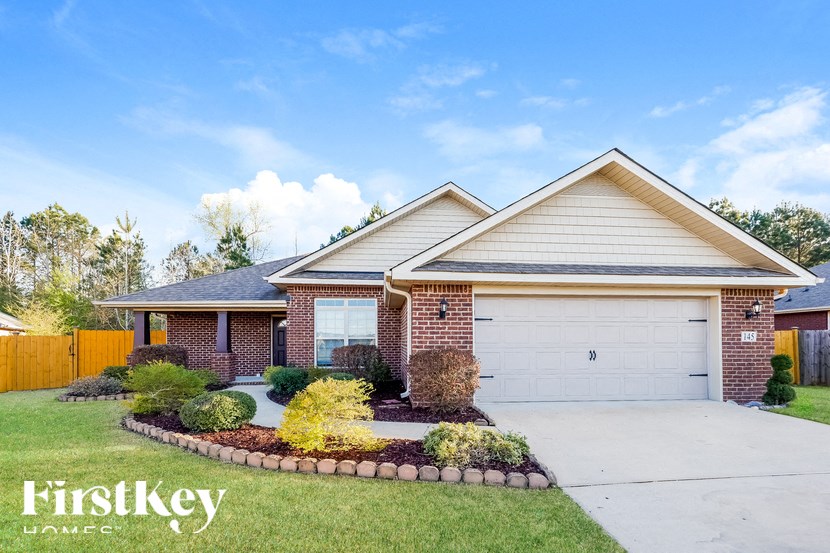A house with a garage and a driveway in front of it.