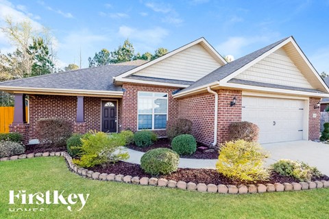 A brick house with a well-maintained garden in front.