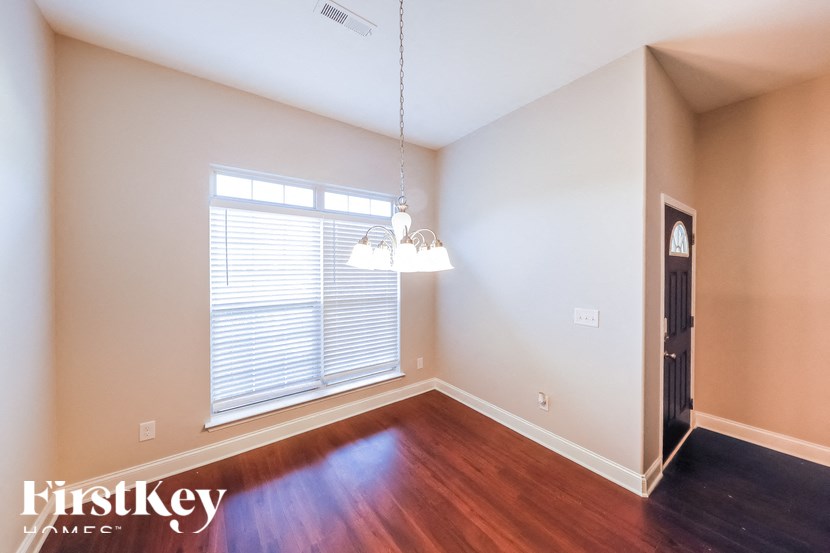 A room with wooden floors and a window with blinds.
