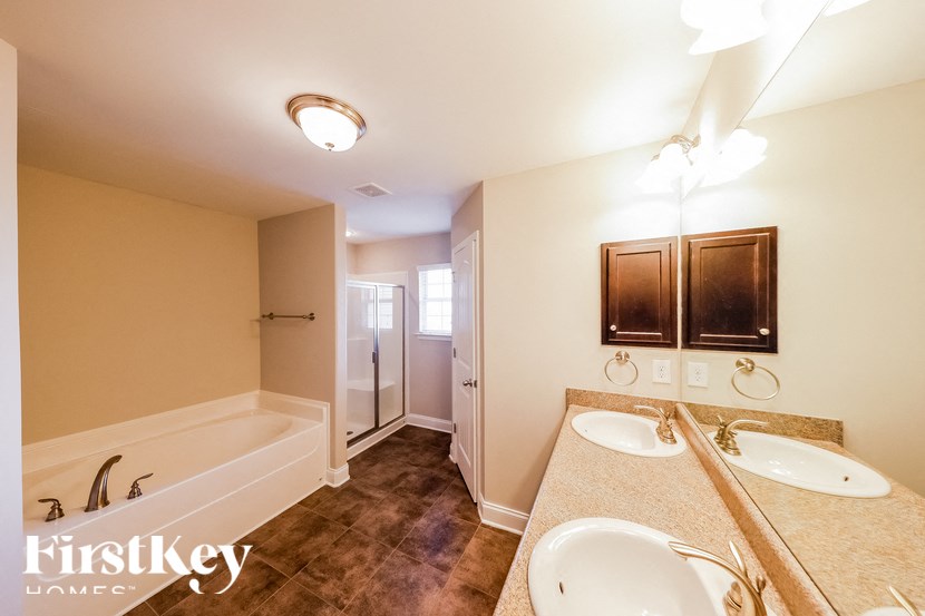 A bathroom with a bathtub, sink, and mirror.