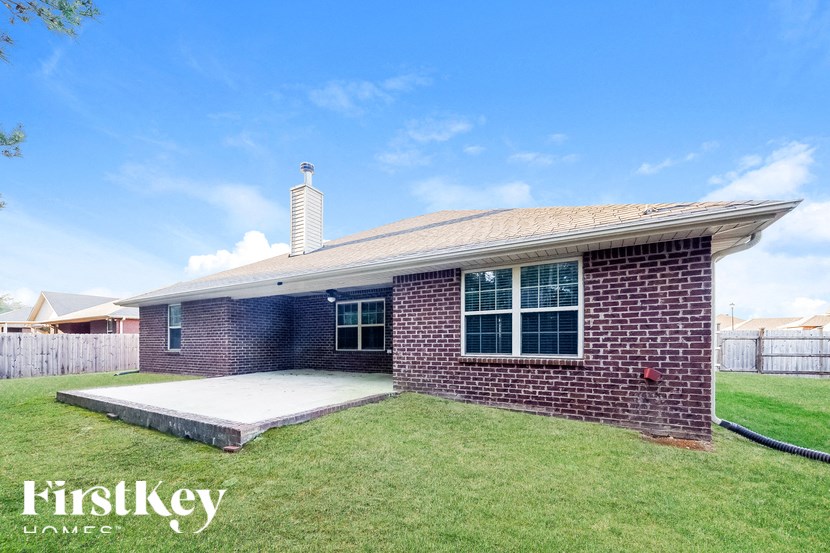 A brick house with a white roof and a covered patio.