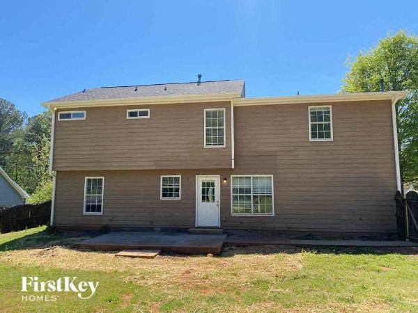 a brown house with a white door and a yard