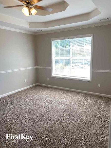 an empty room with a ceiling fan and a window