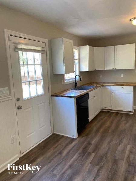 a kitchen with white cabinets and a sink and a door