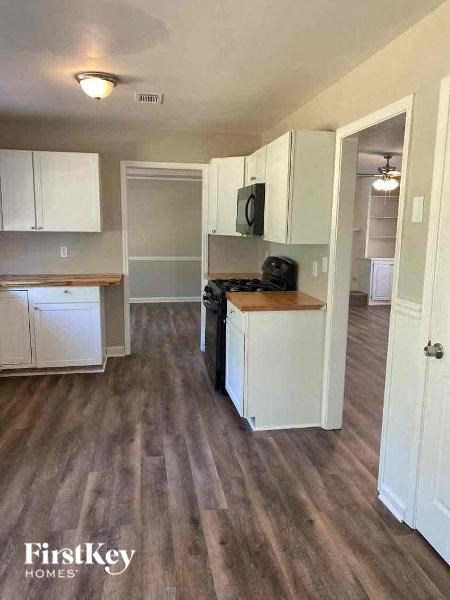 a kitchen with white cabinets and a wood floor