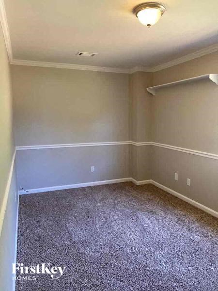 a empty room with a carpeted floor and a lamp