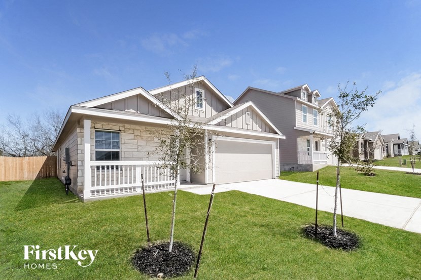 a house with a lawn and trees in front of it