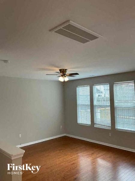 a living room with a ceiling fan and a wood floor