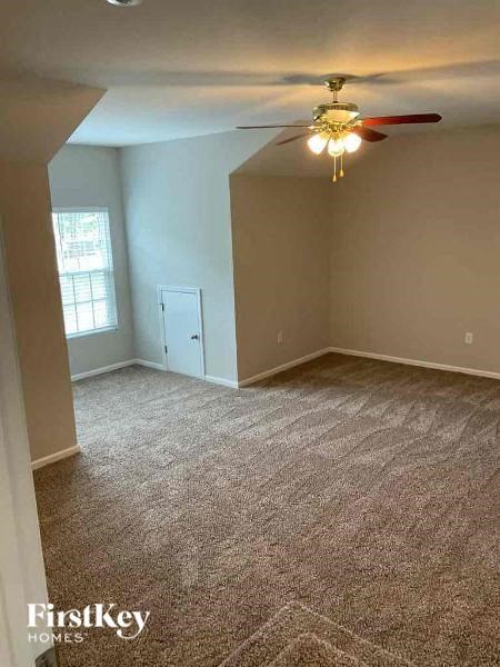 an empty living room with a ceiling fan