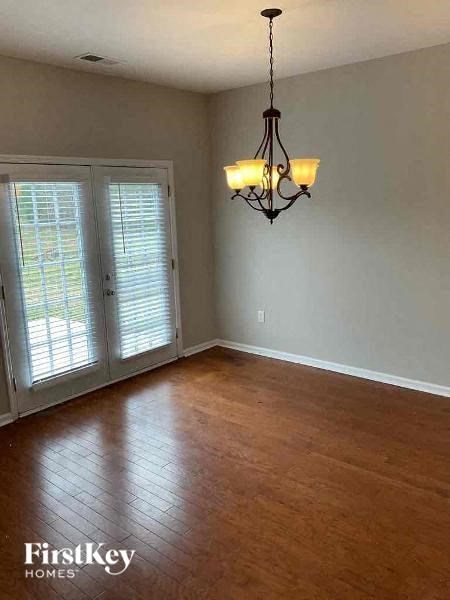 a living room with a wood floor and a chandelier