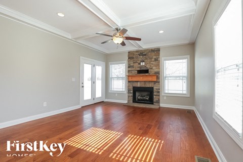 A spacious room with a fireplace and a ceiling fan.