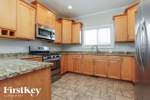 A kitchen with wooden cabinets and granite countertops.