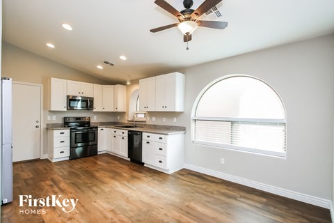 A kitchen with a black stove top oven and white cabinets.