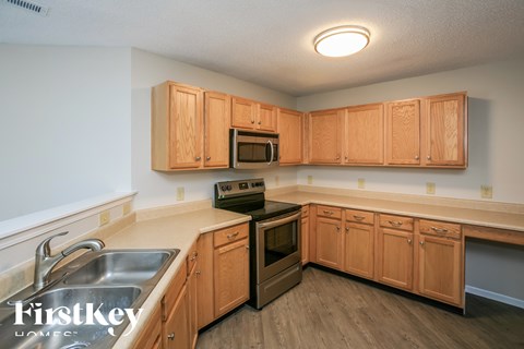 A kitchen with wooden cabinets and a stove top oven.