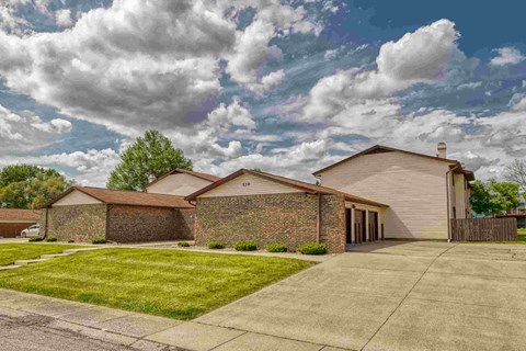 A house with a brown roof and a driveway in front.