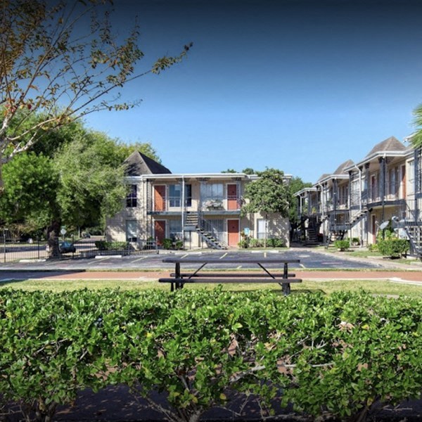 a park with a picnic table in front of some houses
