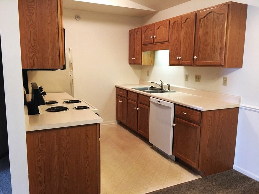 a kitchen with wooden cabinets and a stove and a sink