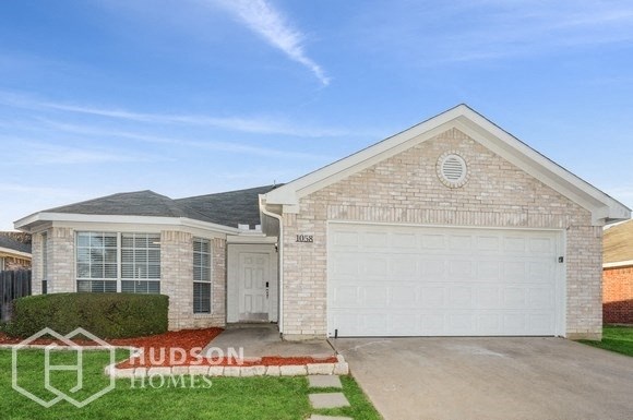 a brick house with a white garage door and a lawn