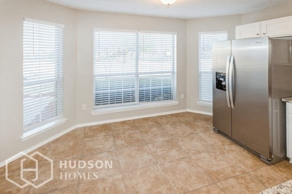 a kitchen with a stainless steel refrigerator and a window