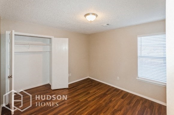 an empty room with a door to a closet and a window