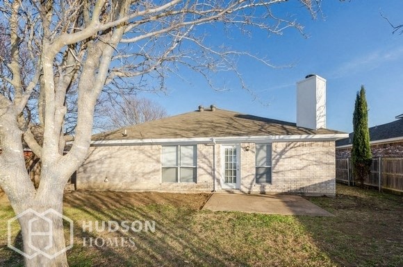 a small white house with a tree in the yard
