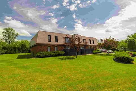 A house with a green lawn in front of it.