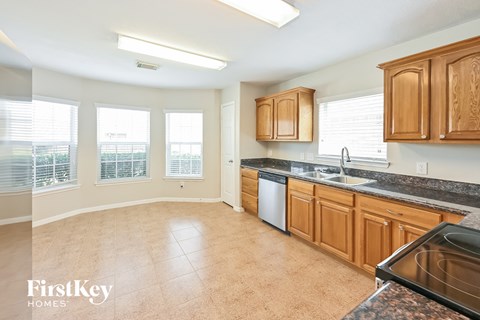 a kitchen with wooden cabinets and granite counter tops and a sink