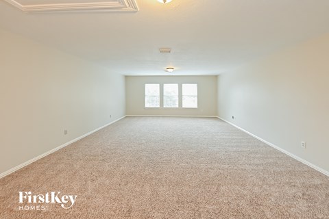 a spacious living room with carpet and a window